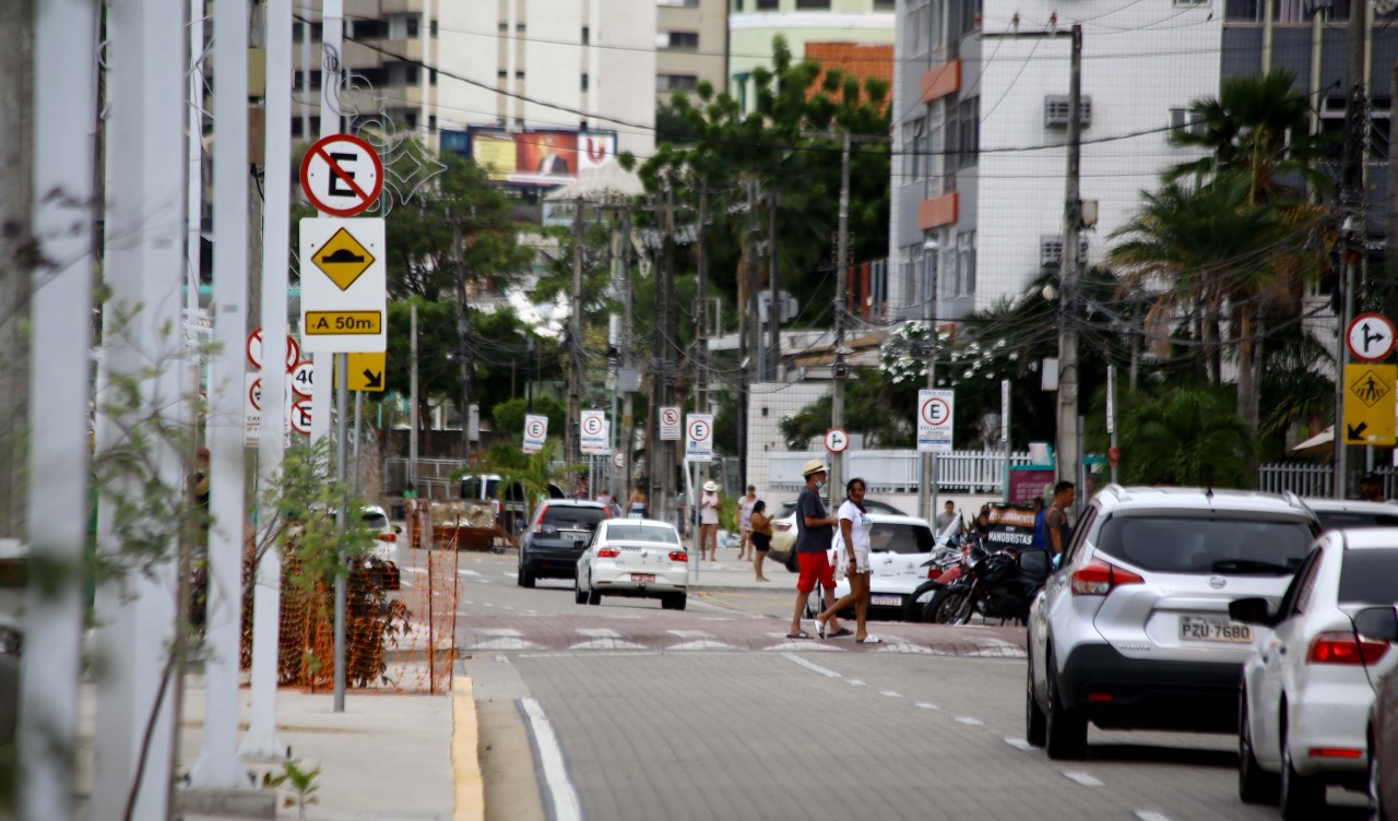 pedestres atravessando uma faixa elevada na beira-mar